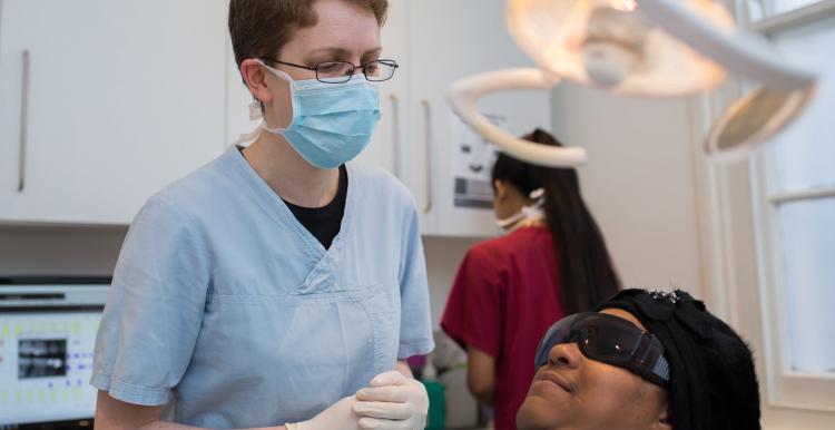 A young female dentist wearing a mask