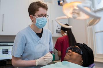 A young female dentist wearing a mask