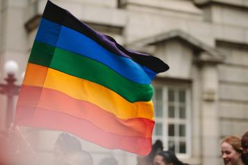 Holding out pride flag in a parade