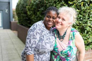 two middle aged woman hugging each other