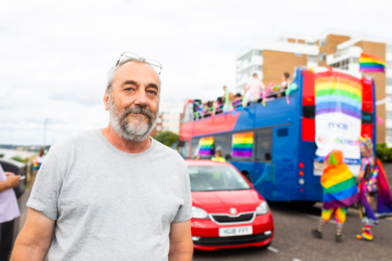 White male standing in front of a bus 