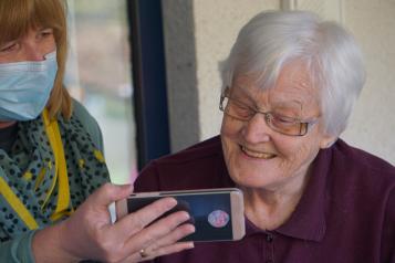 Older lady smiling at her mobile phone
