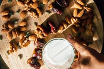 Dates, nuts and milk on wooden table