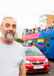 White male standing in front of a bus 